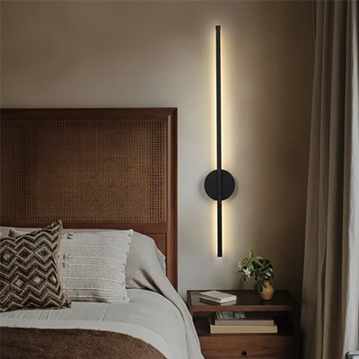 Applique murale led noire à côté d'un lit