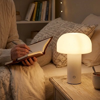 Femme écrit éclairée par une lampe champignon dans une chambre